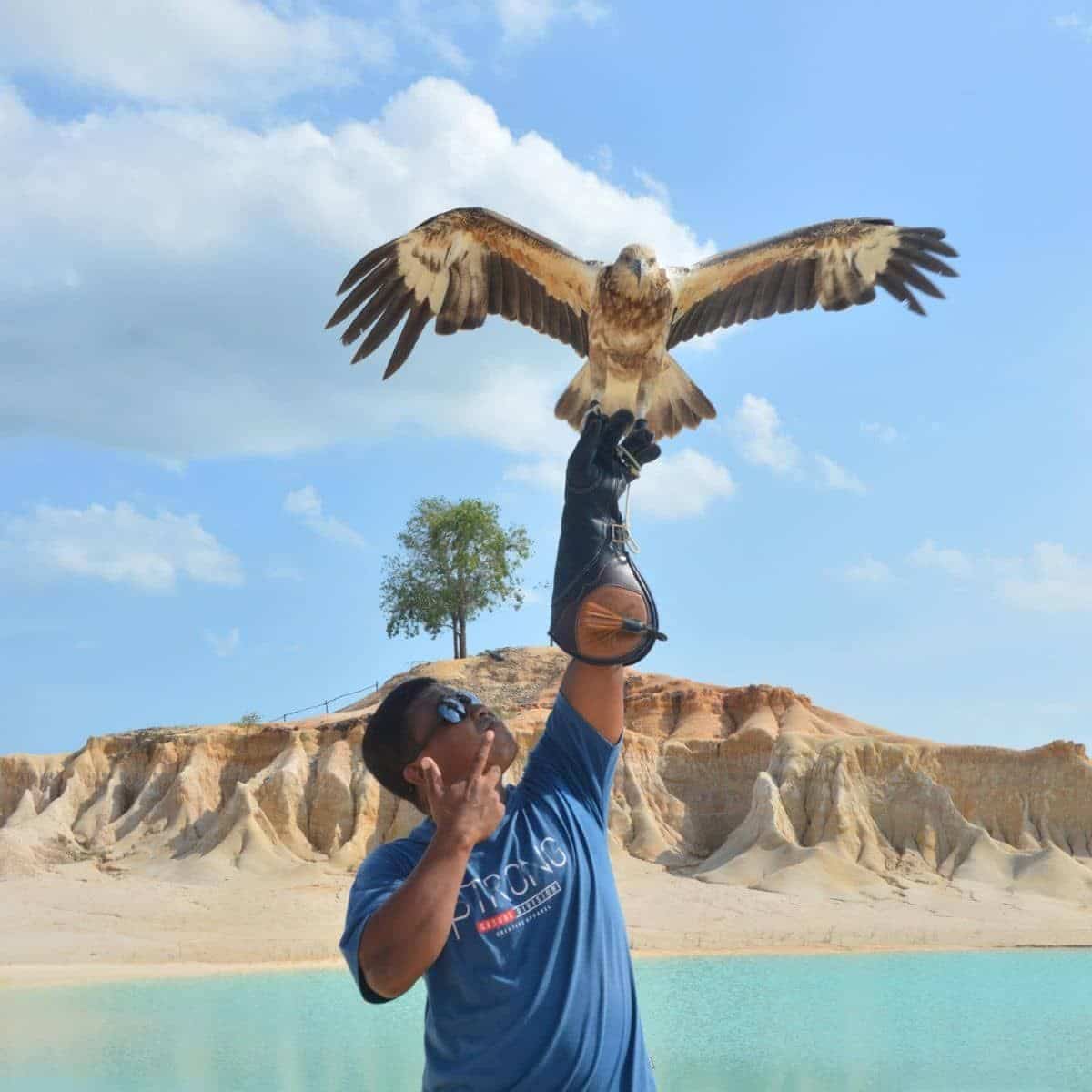 Visitor posing with eagle at Blue Lake Bintan scenic viewpoint