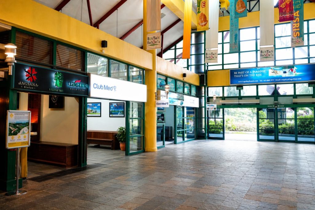 Economy class arrival hall at BBT Ferry Terminal with hotel counters