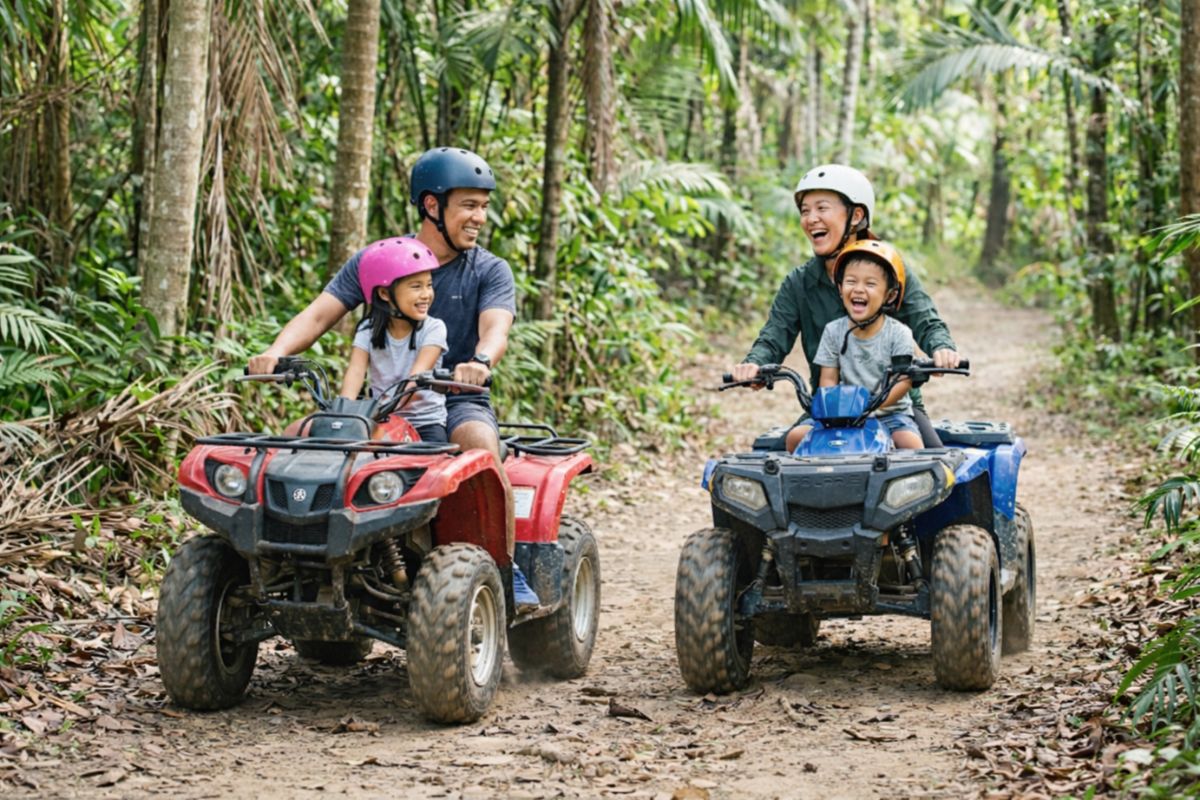 Family riding ATV in Bintan smiling during easy off-road trail ride