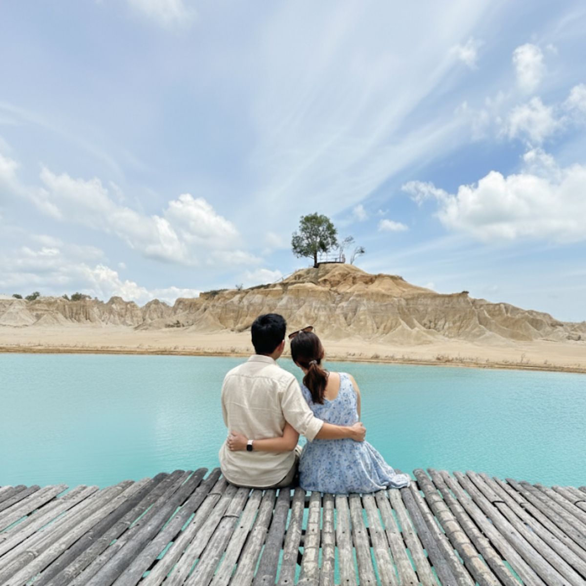 Couple sitting at Blue Lake Bintan viewing deck enjoying scenic lake view