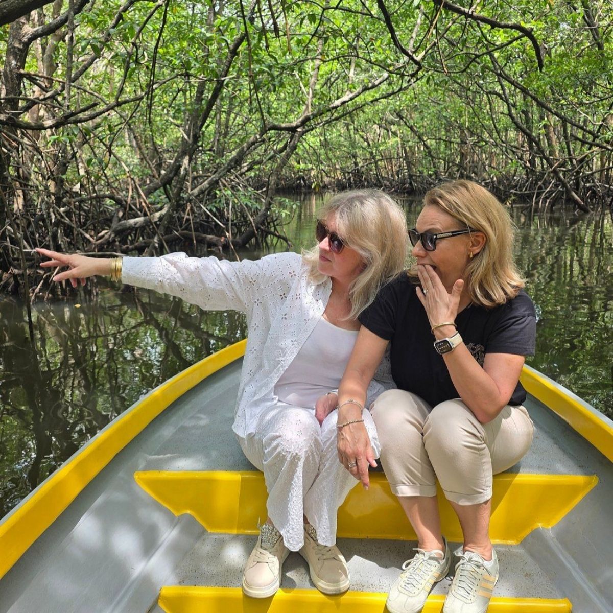 Two female friends on mangrove boat tour Sebung River Bintan smiling and enjoying river cruise