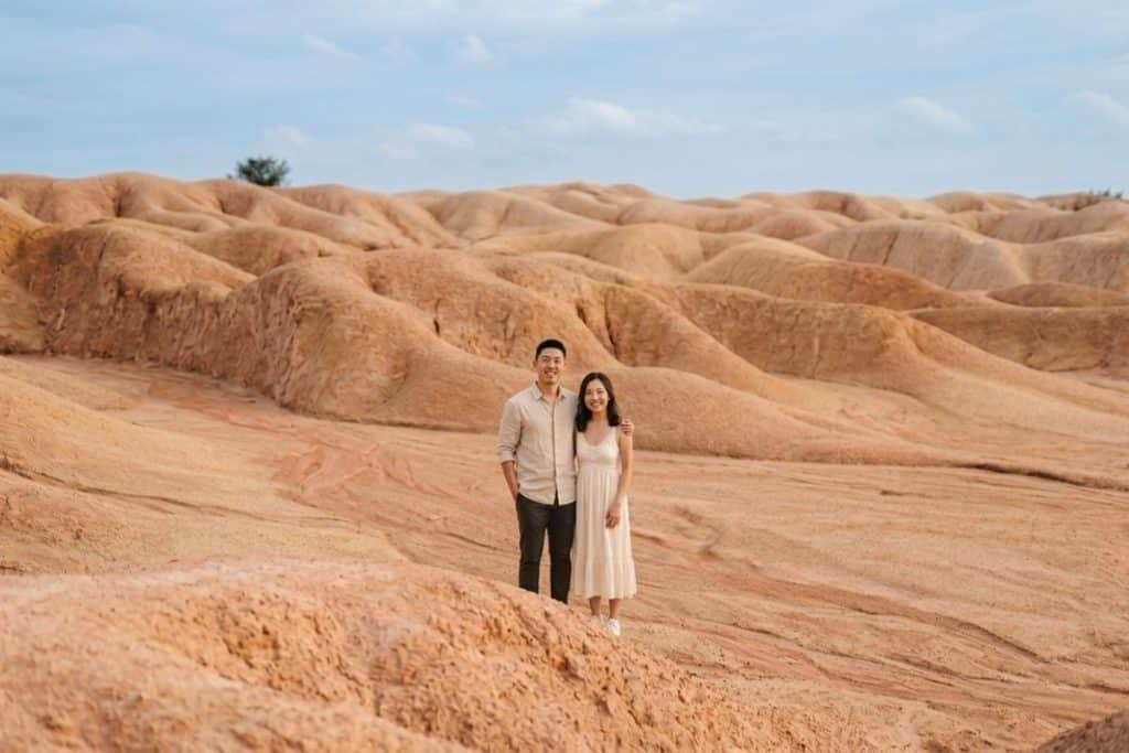 Couple taking photos at Bintan Sand Dunes with white sand hills in the background